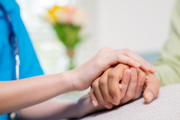 A nurse holding someone's hand