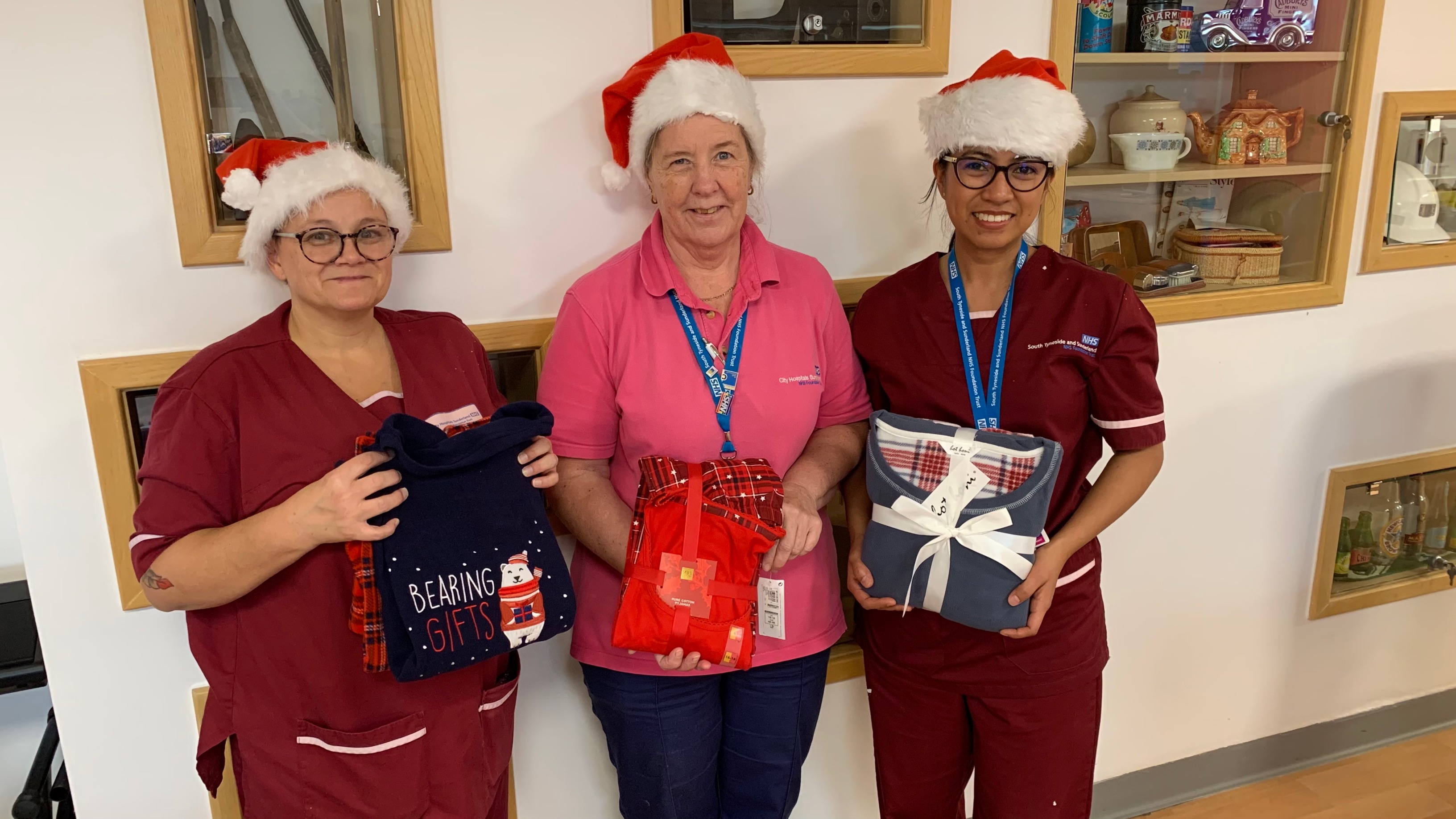 Three ladies holding pyjamas looking at the camera