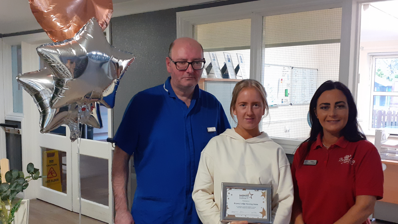 Three people holding a certificate and looking at the camera