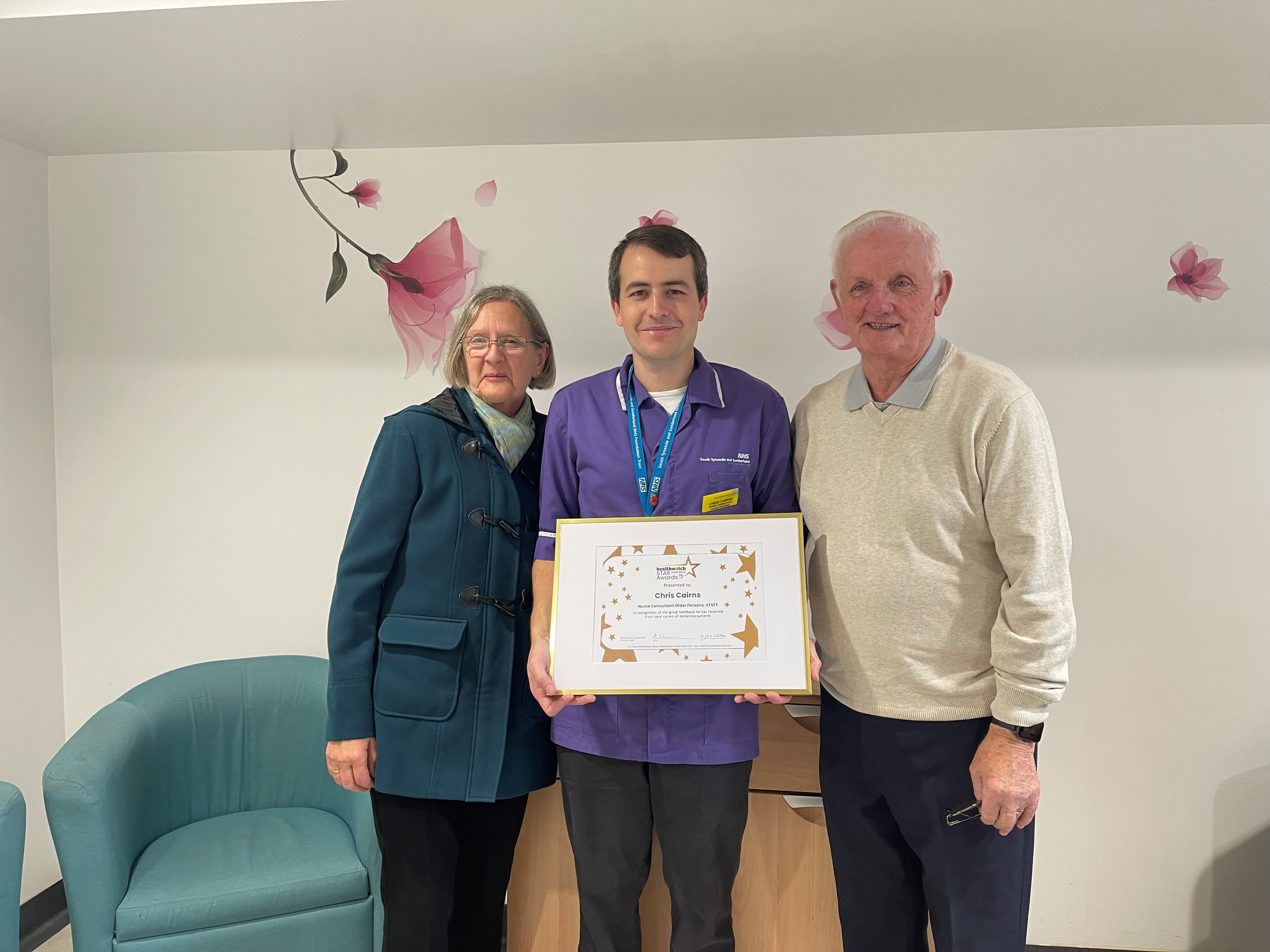 Three people holding a certificate and looking at the camera
