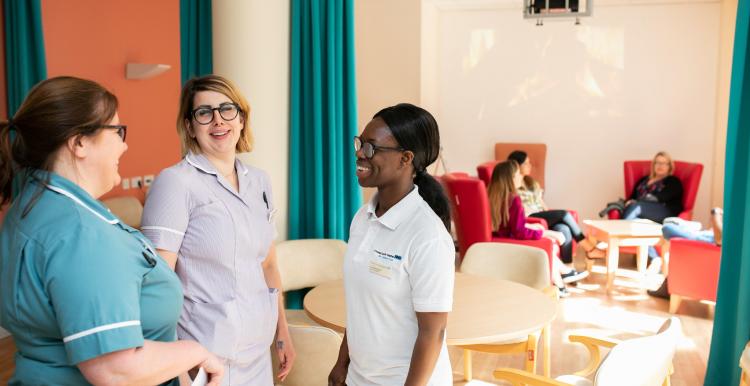 A group of health professionals talking to one another A group of health professionals talking to one another