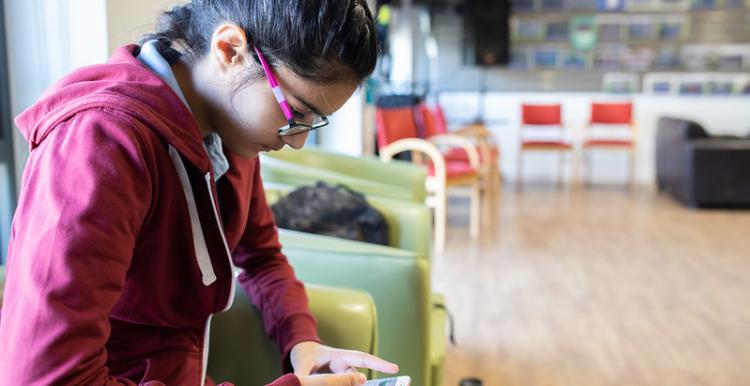 Young person looking at her mobile phone