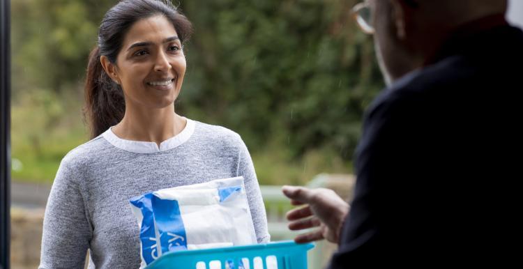 A woman handing a parcel of medications to a gentleman