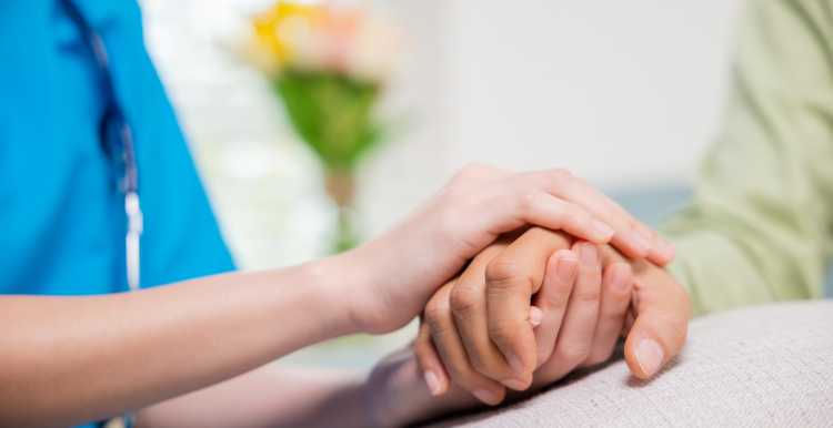 A nurse holding someone's hand