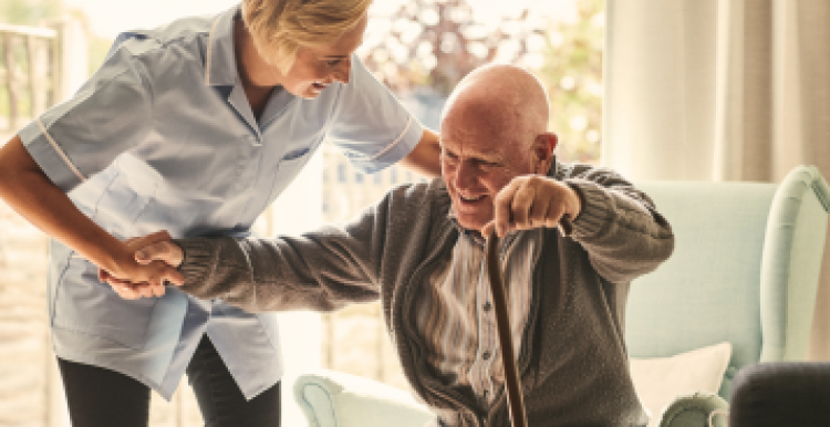 A Nurse helping a man out of a chair