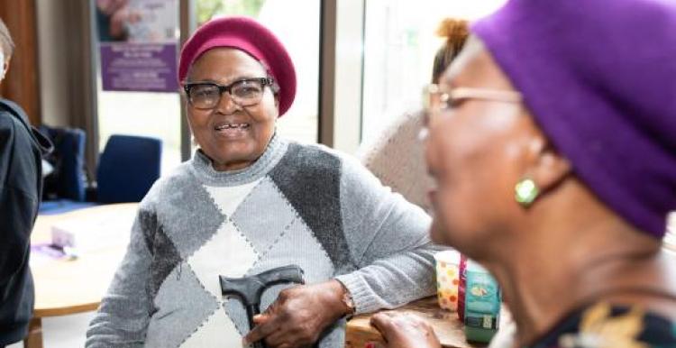 Two women sitting smiling at each other