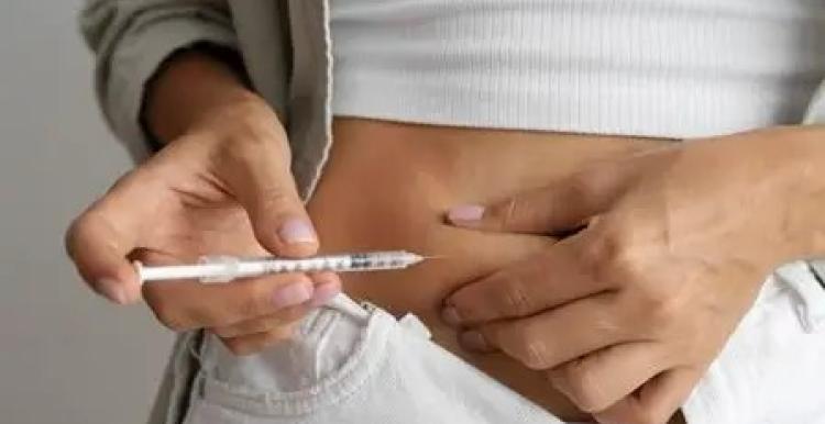 A lady using a needle to inject herself