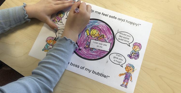 A person sitting colouring in a drawing