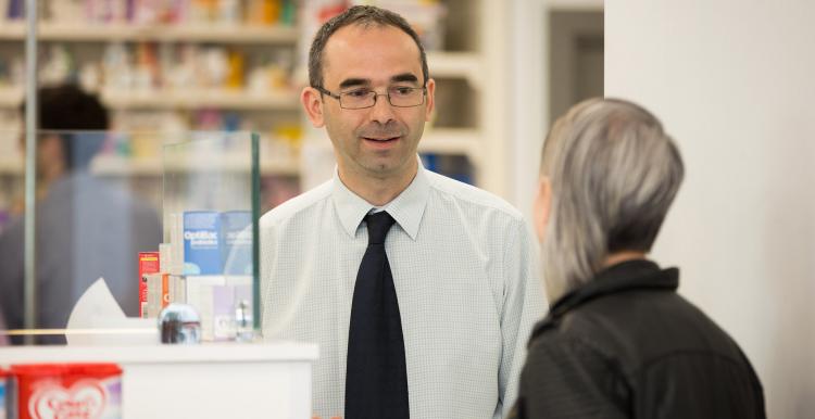 Woman speaking to a male pharmacist Woman speaking to a male pharmacist