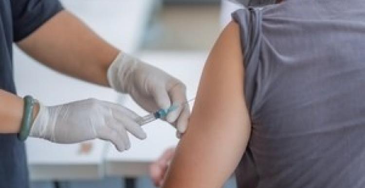 A person injecting someone with the COVID-19 vaccine