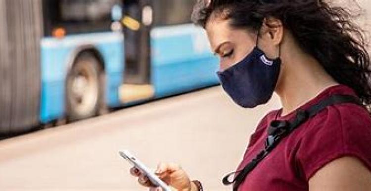 Girl wearing face mask looking at her mobile phone Girl wearing face mask looking at her mobile phone