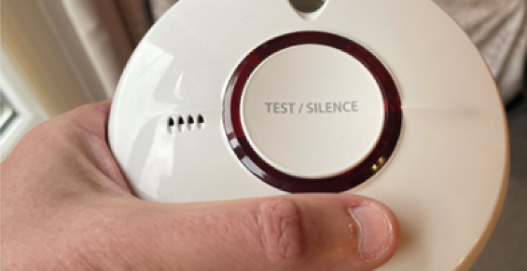 A person holding a smoke alarm