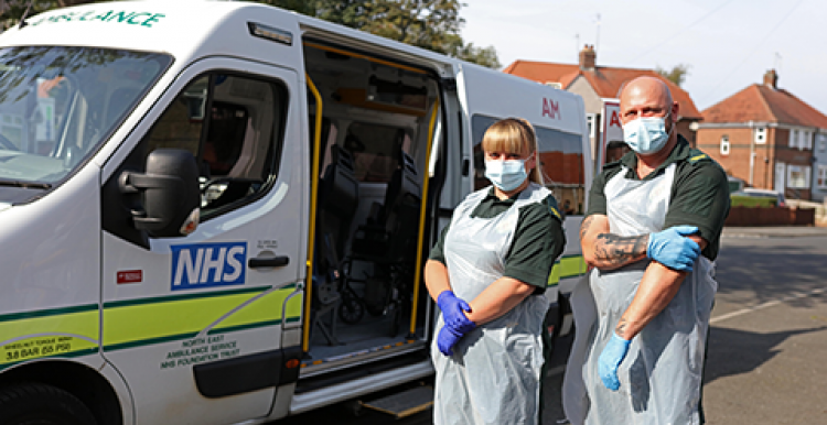 Two people standing in front of a NEAS Transport Vehicle Two people standing in front of a NEAS Transport Vehicle