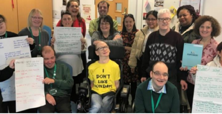 A group of people holding posters looking at the camera