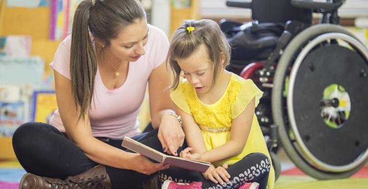 Woman with child with disability reading