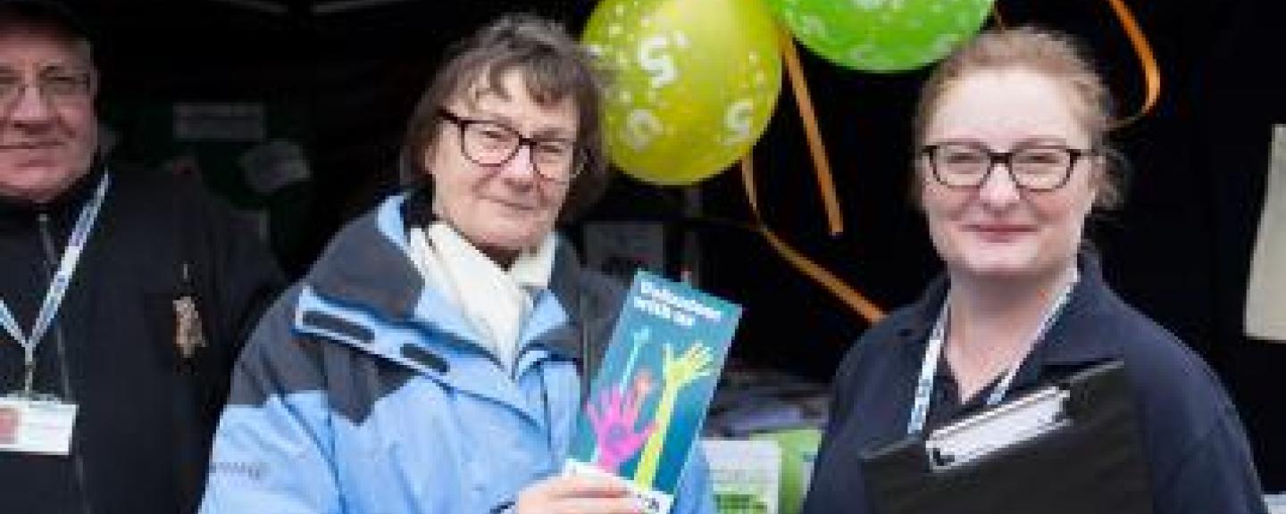 Two Healthwatch volunteers at a stall with Healthwatch balloons