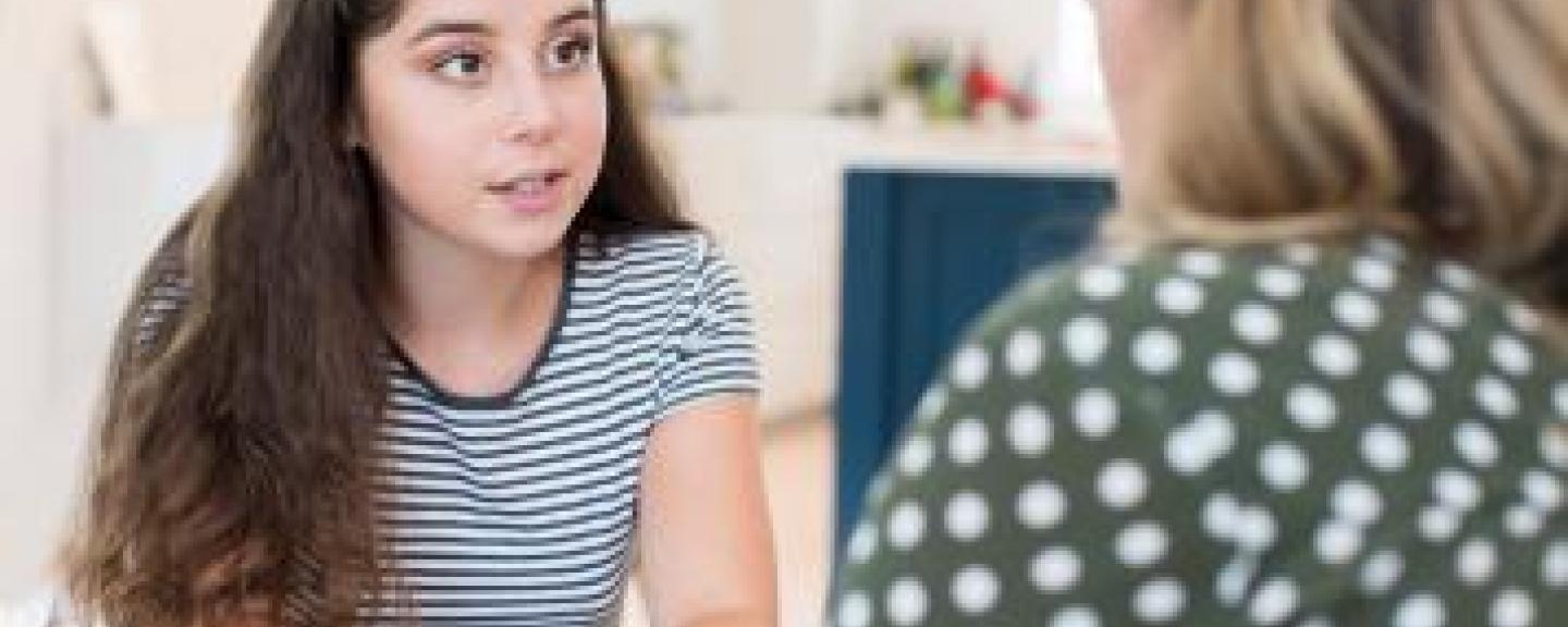 Young woman sitting and talking to an older woman