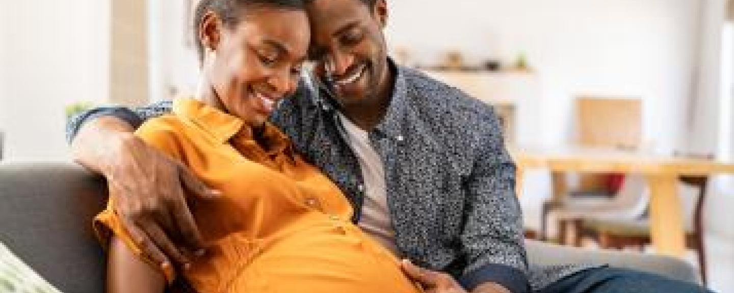 A man looking at a  woman who is pregnant 