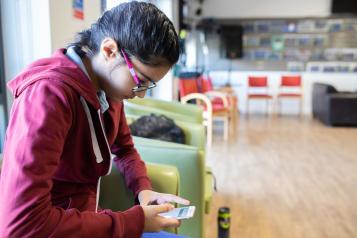 Young person looking at her mobile phone