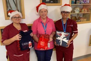 Three ladies holding pyjamas looking at the camera