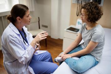 A young woman with a doctor in an exam room