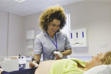 Nurse checking a patient in a hospital bed