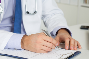 A doctor writing on a form