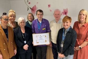 A man standing with a group of people holding a certificate