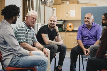 A group of men sitting talking to each other