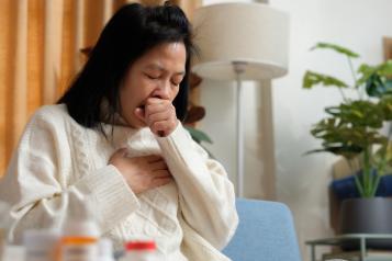  A lady coughing into her hand