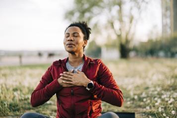 A man with his eyes closed and his hands on his chest