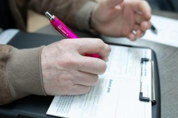 An image of a person's hand using a pen
