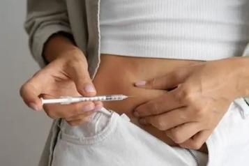 A lady using a needle to inject herself