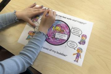 A person sitting colouring in a drawing