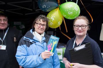 Two Healthwatch volunteers at a stall with Healthwatch balloons