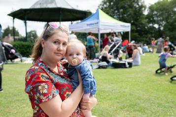 Woman holding a child at an picnic