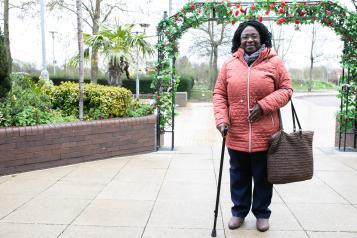 Woman with a walking stick looking at the camera