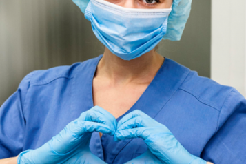 Covid nurse wearing scrubs looking at the camera