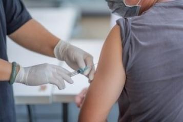 A person injecting someone with the COVID-19 vaccine