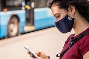 Girl wearing face mask looking at her mobile phone