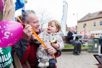 Elderly man holding a young child at an event