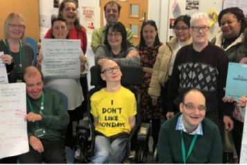 A group of people holding posters looking at the camera