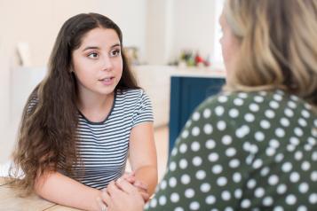 A young woman talking to another woman