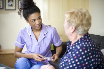 social care working speaking to a lady in her home