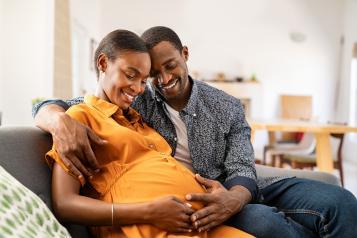 A man looking at a  woman who is pregnant 