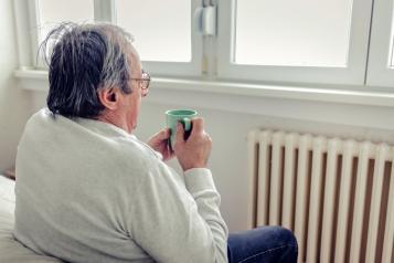 A man sitting in a chair looking out of the window
