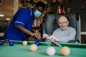 A nurse with a patient playing a table game
