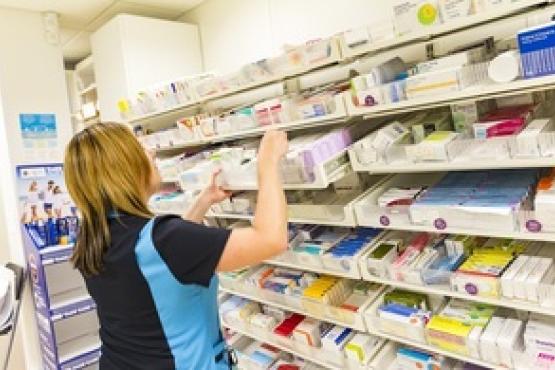 A lady stacking shelves in a pharmacy