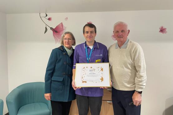 Three people holding a certificate and looking at the camera