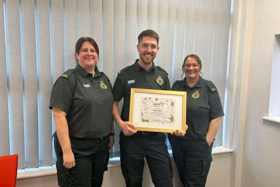 People standing looking at the camera holding a certificate